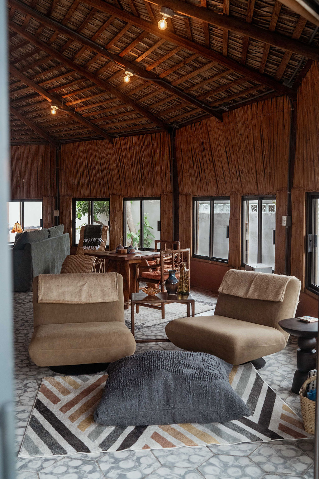 Living room — bamboo walls, low chairs, geometric rug