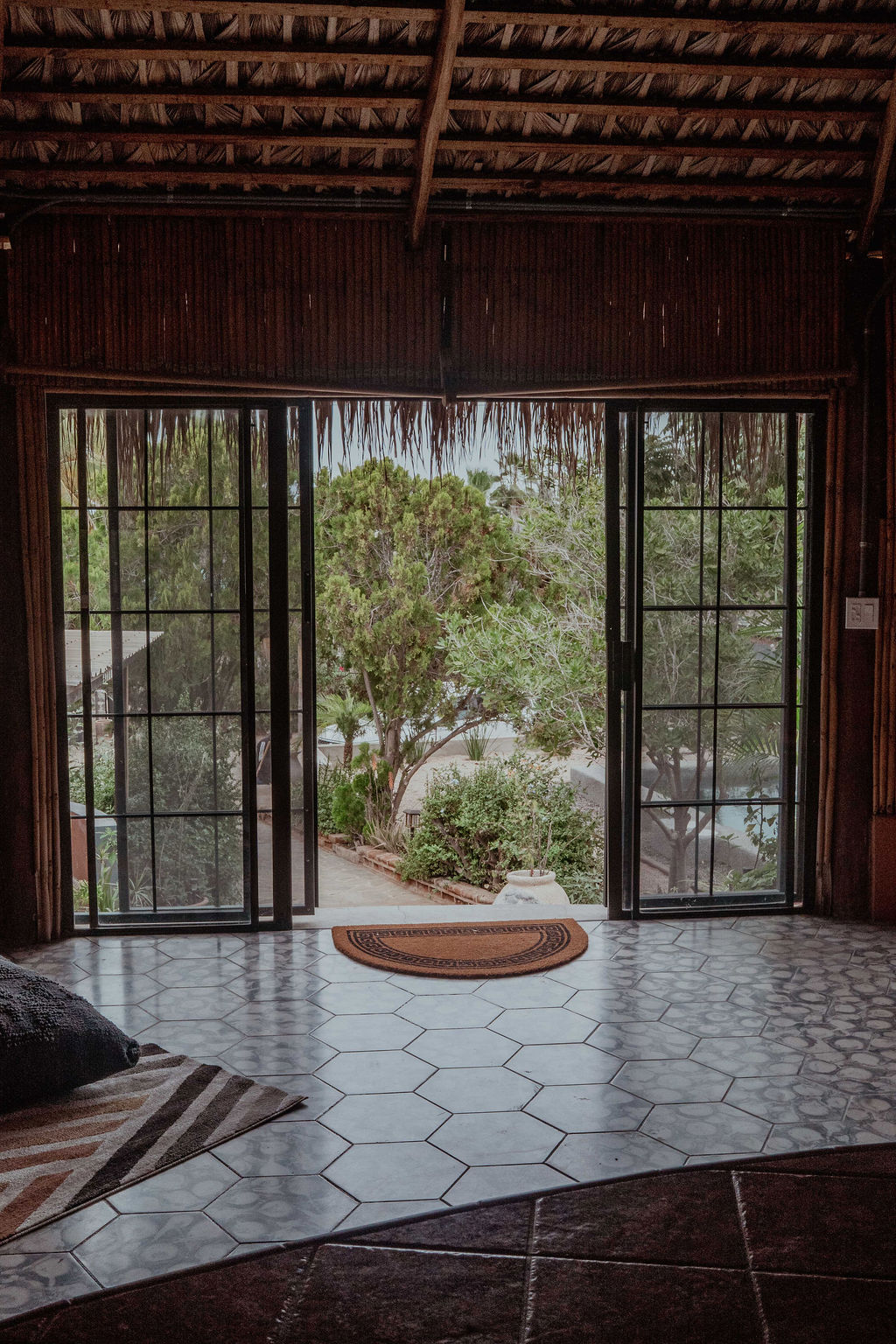 French doors from the palapa opening to the garden and pool