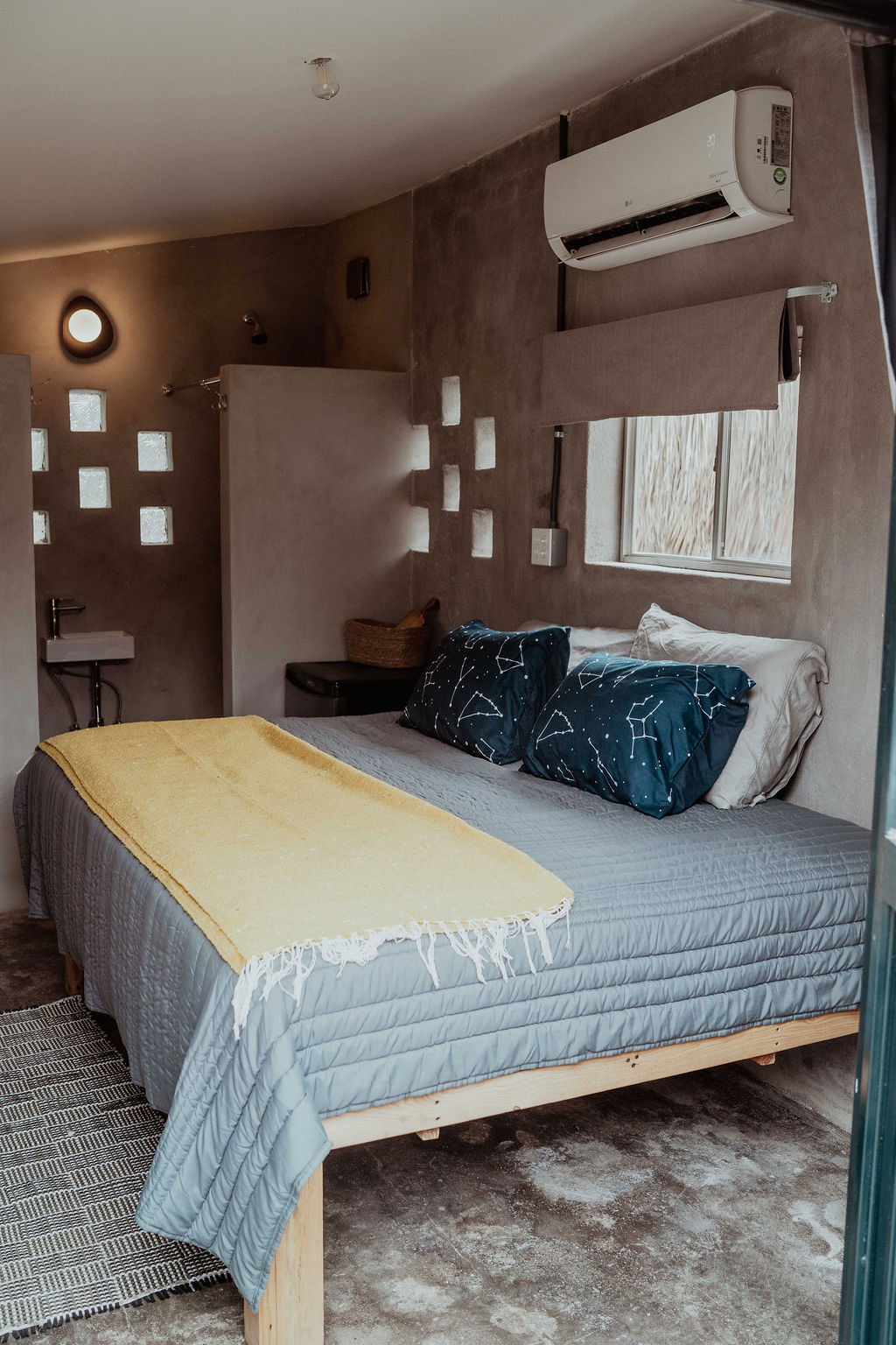 Small casita — constellation pillows, yellow throw, grey walls